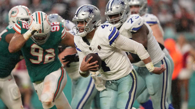 Dallas Cowboys quarterback Dak Prescott (4) runs away from the pressure of Miami Dolphins defensive tackle Zach Sieler (92) during the first half of an NFL game at Hard Rock Stadium in Miami Gardens, Dec. 24, 2023.